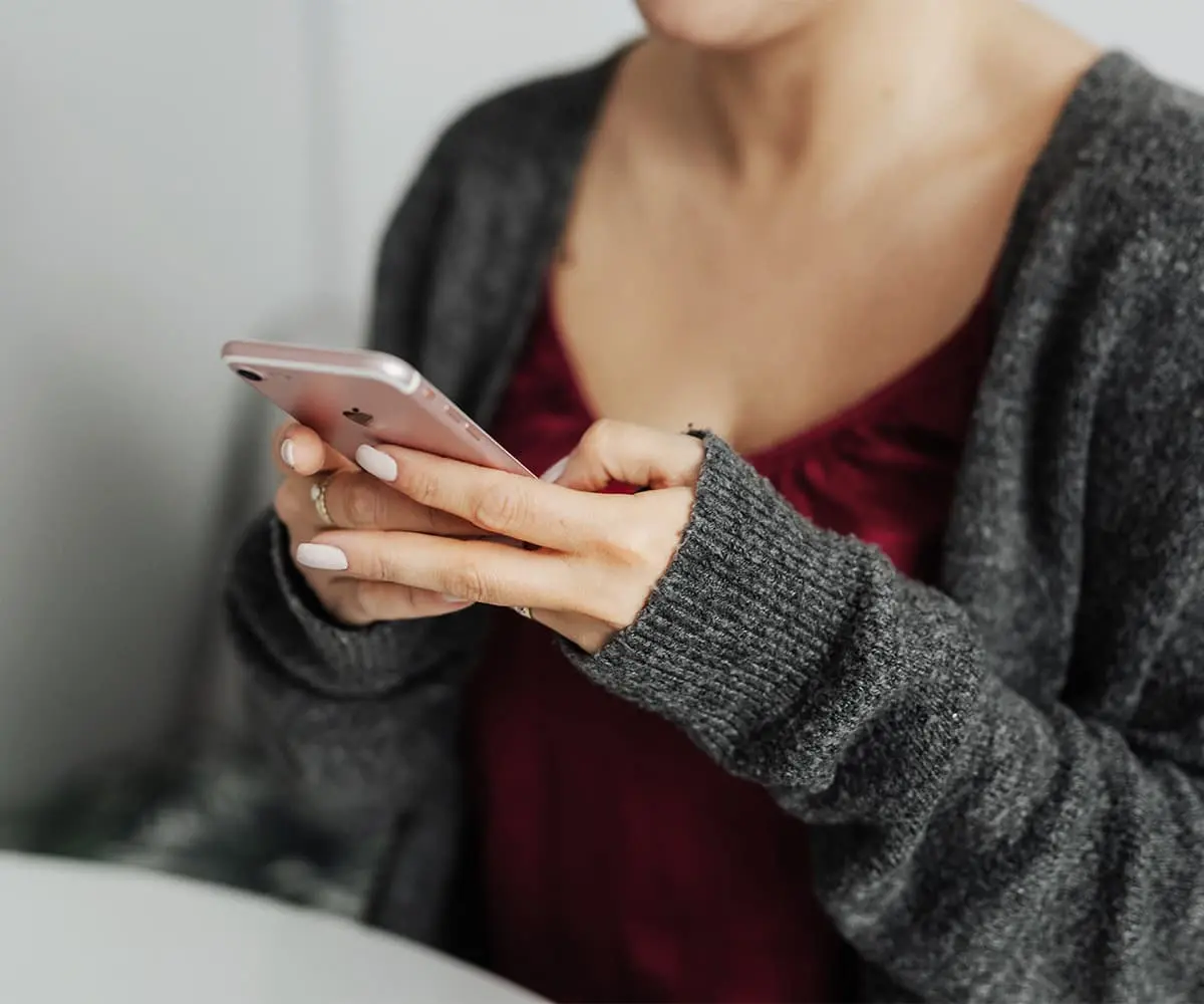 Smartphone in der Hand als Symbol für Newsletter-Flut und digitale Reizüberforderung