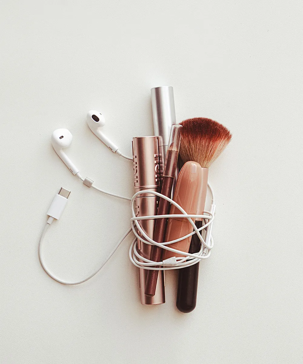 Verknotete Kopfhörer mit Beautyprodukten als Metapher für eine klare Website Struktur