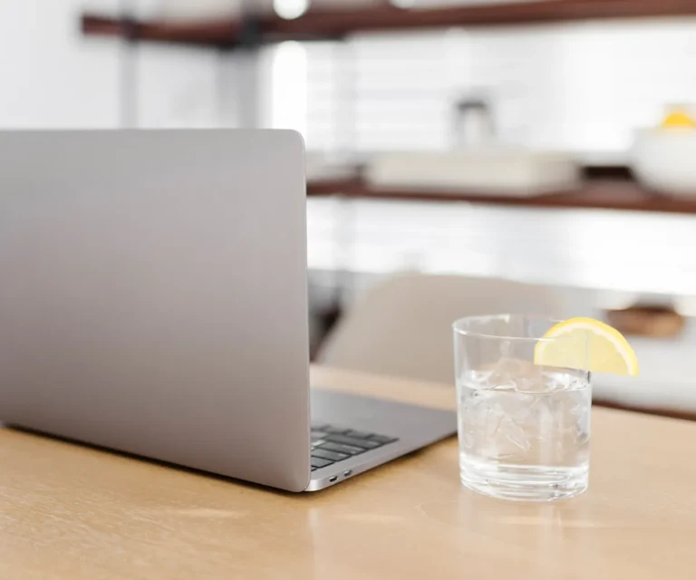 Minimalistischer Arbeitsplatz mit Laptop und Getränk, Symbol für eine Website, die nicht konvertiert