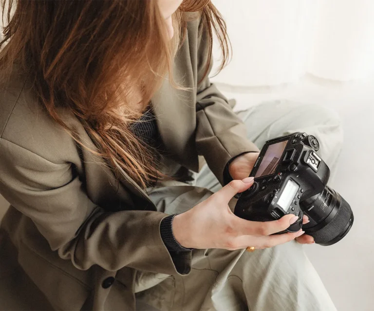 Frau bearbeitet Kamera – Symbolbild für WordPress Bilder optimieren und SEO verbessern